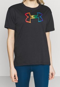 Svart bomullströja med en flerfärgad, stiliserad logotyp i mitten. Kort ärm och en avslappnad passform, med rund halsringning.