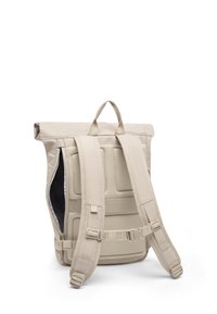 Beige roll-top backpack with padded mesh back panel, adjustable shoulder straps, side zipper pocket, and top carry handle on white background.