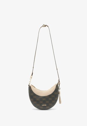 Half-moon crossbody bag in dark green and beige, featuring patterned exterior, gold hardware, and adjustable strap with tassel detail.