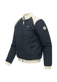 Veste bomber bleu marine avec col et poignets côtelés crème, fermeture éclair à l'avant et détail de logo circulaire sur la manche gauche. Texture de tissu lisse.
