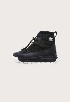 Botte d'hiver noire mi-hauteur avec semelle blanche, lacets à l'avant et logo ours Sorel sur le côté, conçue pour temps froid.