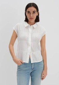 Blusa bianca a maniche corte con un design a pieghe testurizzato e chiusura frontale con bottoni. Presenta un colletto classico e una vestibilità rilassata.