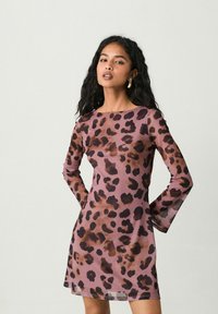 Šaty s leopardím potiskem z průhledné tkaniny s dlouhými rukávy, mají růžové pozadí a tmavě hnědé skvrny, rovný střih, nad kolena.