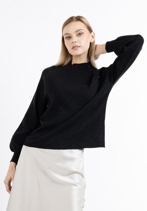 Schwarzer Pullover mit Rundhalsausschnitt, strukturiertem Gewebe mit silbernen Fäden und oversized Ballonärmeln, kombiniert mit einem Satinnenrock.