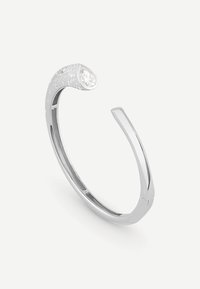 Srebrna bransoleta mankietowa ze sterlinowym srebrem i zakrzywionym wzorem. Na jednym końcu znajduje się przezroczysty, zaokrąglony kamień szlachetny, a wzdłuż opaski zarysowane są teksturowane detale.