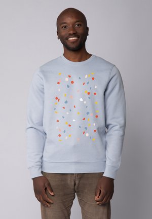 Lichtblauwe sweatshirt met een kleurrijk spikkelpatter in rood, geel en pasteltinten. Beschikt over een ronde halslijn en ribboorden.