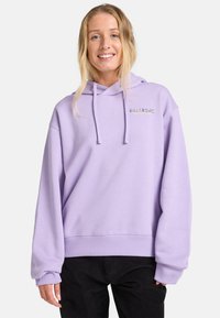 Sudadera con capucha color lila en tejido suave, con un bolsillo tipo canguro en la parte frontal y puños y dobladillo acanalados. Presenta un logo de la marca bordado en colores contrastantes.