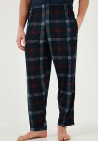 Pantaloni de pijama cu carouri marine, cu accente roșii și albe, au o talie elastică și buzunare laterale, fiind fabricați dintr-o țesătură moale și confortabilă.