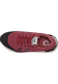 Röd mesh sportskor med svart gummitåkapp; har snörningsdesign och framträdande logotyp. Visar texturerade detaljer och kontrasterande accenter.