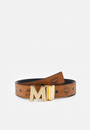 Brown leather belt featuring a gold "M" buckle, diamond patterns, and embossed "MCM" logo. Smooth texture with contrasting black accents.