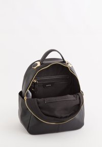 Czarna skórzana plecak z złotym zapięciem na suwak, z przednią kieszenią i wewnętrznymi przegrodami, gładką teksturą, zaokrąglonym kształtem i uchwytem u góry.