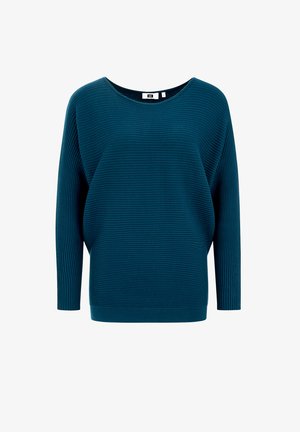 Sinine soonik, millel on lai ümar kaelus ja pikad varrukad. Kangas sisaldab tekstuurset mustrit ja on vabalt istuv.