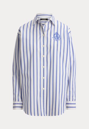 Λευκό πουκάμισο με κουμπιά, κάθετες μπλε ρίγες, μακριά μανίκια, γιακάς και κεντητό μπλε σήμα στο αριστερό στήθος.