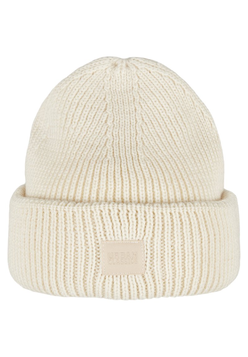 Krémová pletená čiapka s prehnutým okrajom, ktorá má vertikálne rebrovanie a našitú značkovú etiketu vpredu. Mäkká textúra.