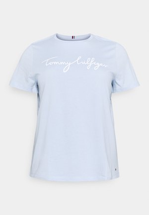 Jasnoniebieska koszulka z krótkim rękawem i okrągłym dekoltem, białym napisem "Tommy Hilfiger" na piersi oraz małym logo blisko dołu.
