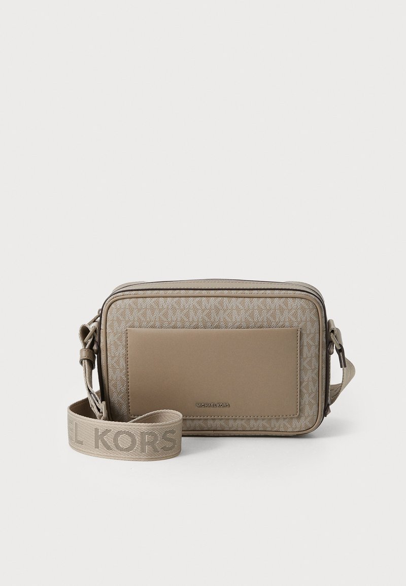 Beige crossover-veske med teksturert stoffdesign og glatte aksenter. Har logobånd og en flat lomme foran. Kompakt rektangulær form.
