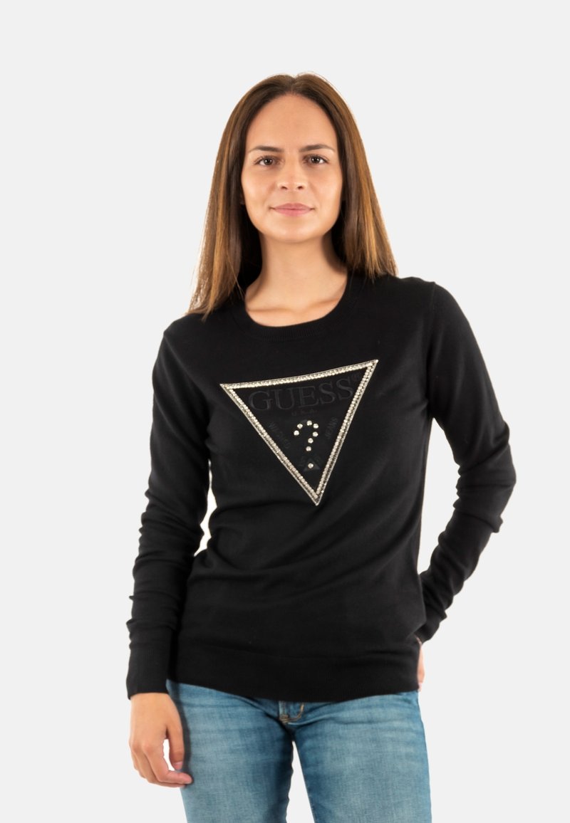 Sudadera negra de manga larga, con un diseño de corte en forma de triángulo que presenta un logo brillante de "GUESS" y tachuelas decorativas.