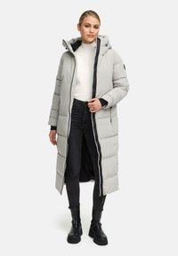 Cappotto imbottito lungo grigio con cappuccio, chiusura frontale con zip e tasche laterali. Presenta un motivo trapuntato e dettagli accentuati in nero.