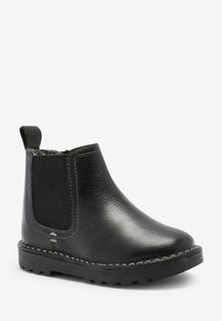 Bottine en cuir noir à cheville avec des panneaux élastiques sur les côtés, une tige texturée, une languette de tirage et des détails cousus sur la semelle pour une meilleure adhérence.