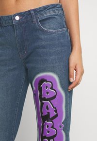 Jaded London LOW RISE BABY GIRL GRAFFITI PRINT - Calças de ganga bootcut - multi