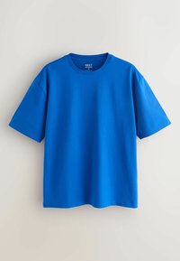 T-shirt uni bleu vif à manches courtes et col rond, taille moyenne, suspendu sur un fond clair uni.