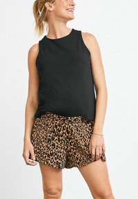 Sort ærmeløs top med rund hals, kombineret med leopardmønstrede shorts, der har brune og sorte mønstre, blødt stof og en afslappet pasform.
