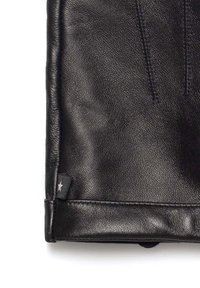 Czarna skórzana sakiewka o fakturowanej powierzchni, gładkich krawędziach i małej bocznej metce z motywem gwiazdy.