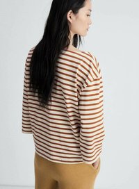 Haut à manches longues rayé en crème et terracotta, présentant une coupe décontractée avec un encolure large et en coton doux.