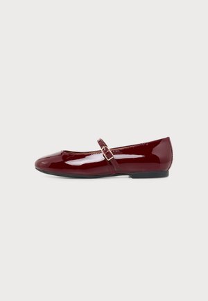 Scarpa Mary Jane piatta, lucida e rosso scuro, con cinturino sottile e fibbia dorata su sfondo bianco.