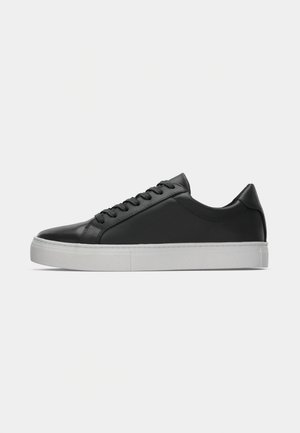 Black leather low-top sneakers with rounded toe, lace-up front, and white rubber sole. Smooth texture with minimalistic design elements.