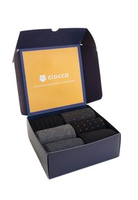 Box-Set mit sechs Socken in verschiedenen Schwarz- und Grautönen, einschließlich gestreifter, gepunkteter und einfarbiger Stile, mit einem gelben Innenfutter.