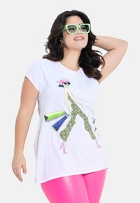 Maglietta bianca a maniche corte con una grafica vivace che raffigura una donna in pantaloni con stampa leopardata, abbinata a dettagli rosa e occhiali da sole colorati.