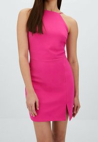 Robe rose ajustée à col licou avec une fente latérale, texture lisse, sans motifs et détails de quincaillerie minimalistes, créant une silhouette élégante.