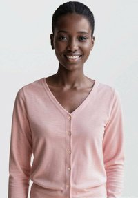 Ljusrosa cardigan i mjukt tyg, med V-ringning, långa ärmar och små knappar fram för stängning.