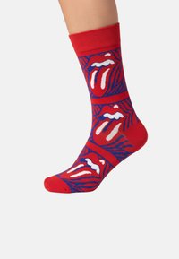 Røde bomuldsstrømper med et mønster af læber og en tunge i hvid og blå, med ribbet kant og glat tekstur.