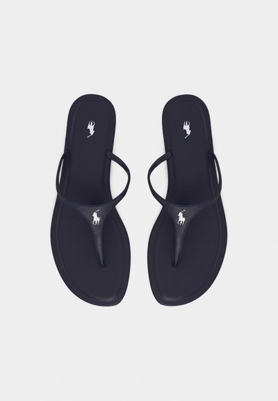 Ζευγάρι μαύρες σανδάλες τύπου thong με λεπτές λουρίδες και λευκά λογότυπα παίκτη πόλο στα πέλματα και στα λουριά, τοποθετημένες επίπεδα σε λευκό φόντο.