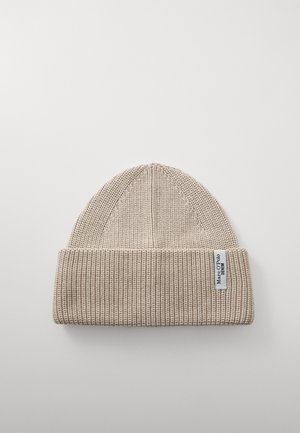 Beige strikket lue med ribbet tekstur, brettbar kant, og en liten merkeetikett på siden. Flat toppdesign.