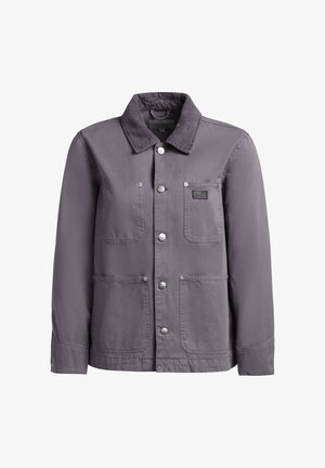 Pelēka pogām aizdares jaka ar korduroja apkakli, krūšu kabatu ar etiķeti un divām apakšējām priekšējām kabatām, attēlota uz balta fona.