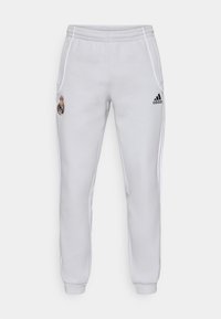 Pantaloni da tuta bianchi Adidas con cintura elastica, tasche laterali e dettagli neri. Presenta una patch con il logo sulla coscia sinistra.