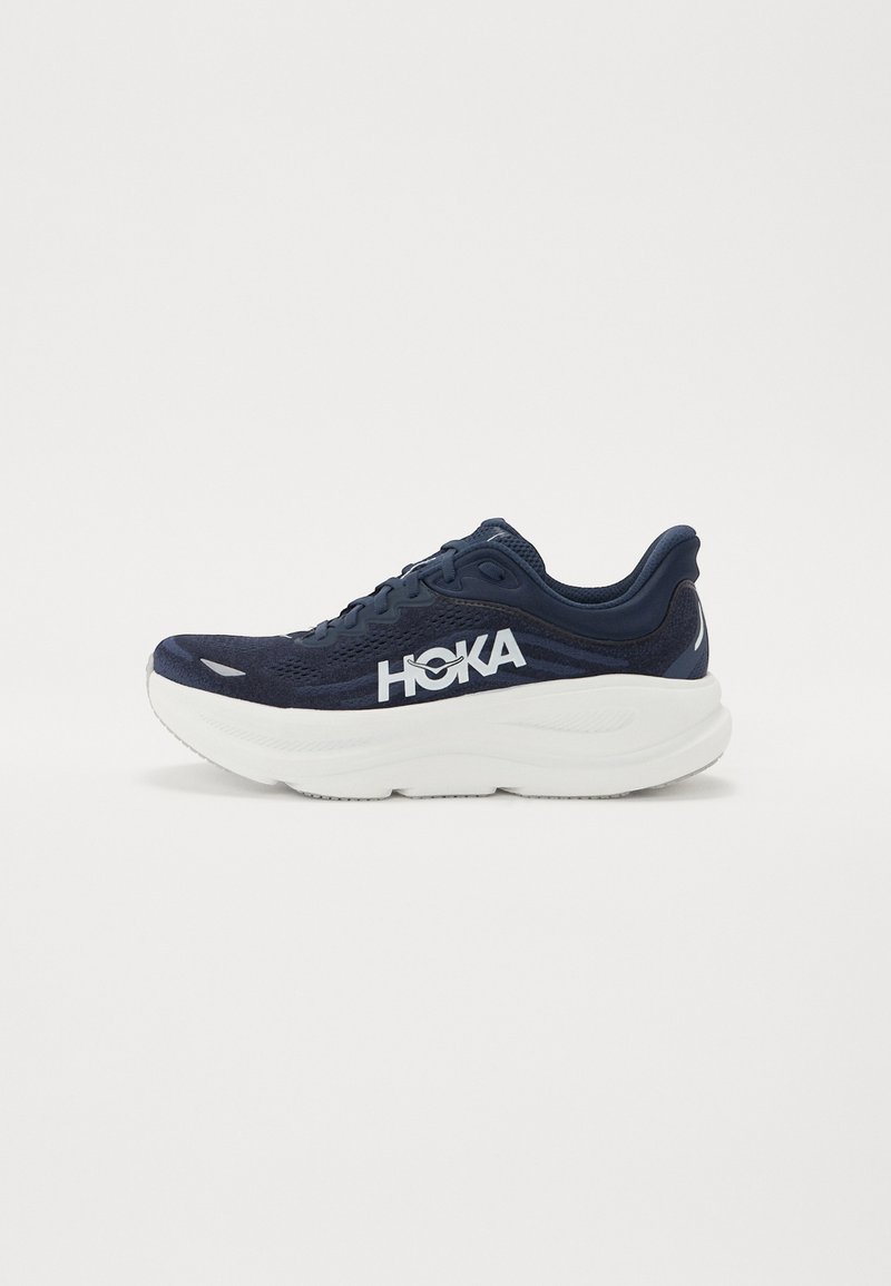 Navy running shoe with mesh fabric upper, white midsole, and prominent white logo. Features a cushioned sole and textured detailing.