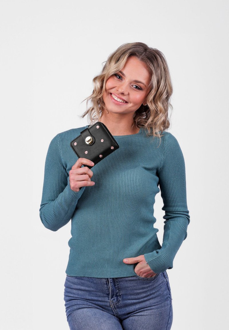 Teal ribbed sweater with long sleeves, paired with a small black wallet featuring gold accents and pink studs, held against a plain background.