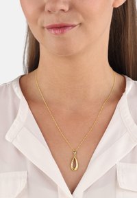 Goldanhänger-Halskette mit einem tropfenförmigen Design, ausgestattet mit einer gedrehten Kette. Der Anhänger hat eine polierte Oberfläche und einen hohlen Mittelpunkt.