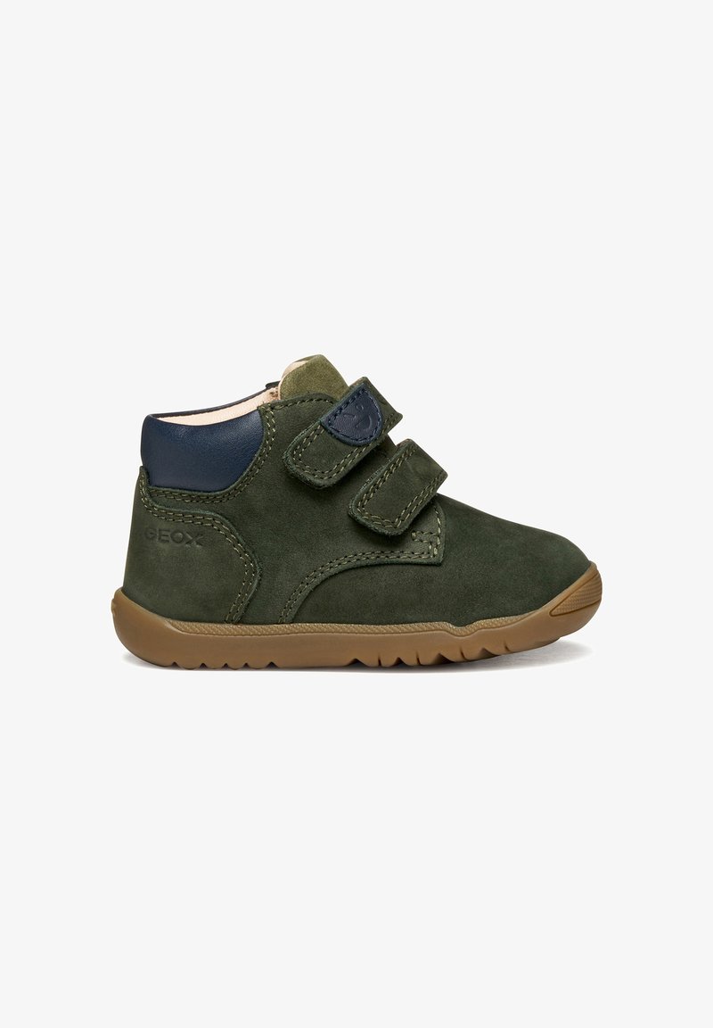Grüne Wildleder-Stiefelette mit marineblauen Akzenten, zwei verstellbaren Klettverschlüssen und einer Gummisohle mit strukturiertem Profil.