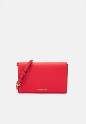 Sac bandoulière en cuir granuleux rouge avec bandoulière réglable et logo "Michael Kors" doré au centre avant.