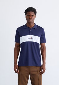 Marineblå polo skjorte med en hvit horisontal stripe, med en logo i midten. Laget av glattsittende stoff med klassisk krage og knapper.