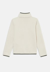 Pull en fleece couleur crème avec un col haut, une surface texturée et un contraste de bordures vert foncé au col et à l'ourlet.