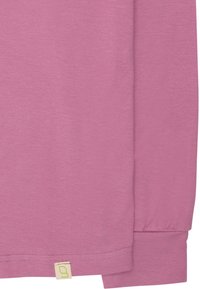 Camicia a maniche lunghe in tessuto rosa chiaro. Presenta polsini elasticizzati e un piccolo etichetta del marchio con un logo verde vicino all'orlo. Texture liscia.