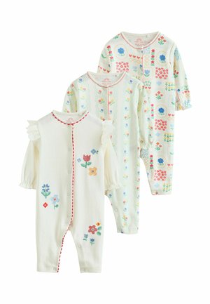 Tri krémové detské overalíky s farebnými kvetinovými vzormi a dlhými rukávmi, s gombíkovými zapínaniami a volánikovými detailmi na ramene na jednom overalíku.