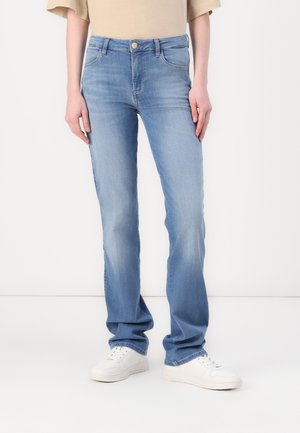 Light blue denim jeans with a straight fit, featuring a buttoned waistband, belt loops, and five pockets. Styled with white sneakers.