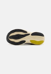 Semelle de chaussure avec un design multicolore, un accent texturé jaune, des rainures en caoutchouc noir, et une semelle intermédiaire beige pour le confort.